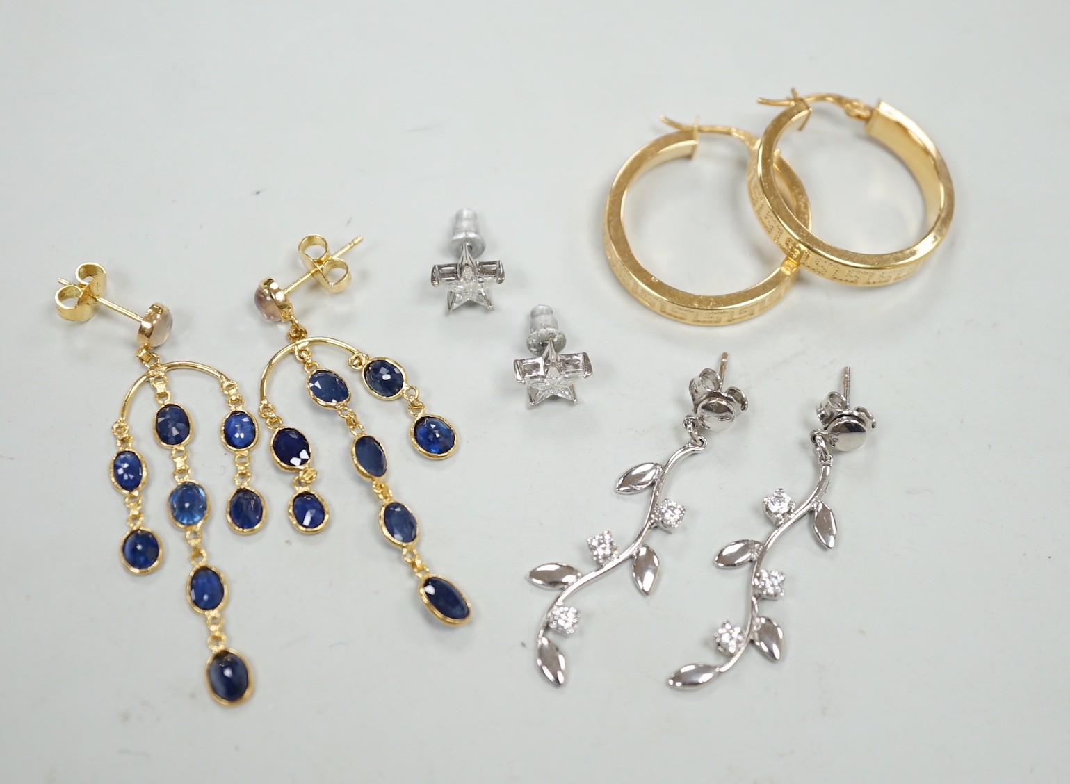 A modern pair of 18ct white gold and diamond cluster set star ear studs, 8mm, gross weight 1.1 grams, a similar pair of 14k, moonstone and sapphire cluster drop earrings, gross 3.5 grams and two pairs of 9ct earrings, gr